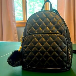 Kids mini black backpack with mini compartments inside and keychain on zipper